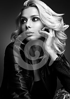 Black and white sensual portrait of a beautiful young woman. Blonde in leather jacket