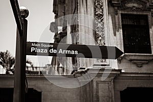 Black and white (sepia) sign pointing to Plaza de Armas in Lima, Peru photo