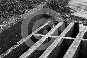 Black and white sewer grate is close