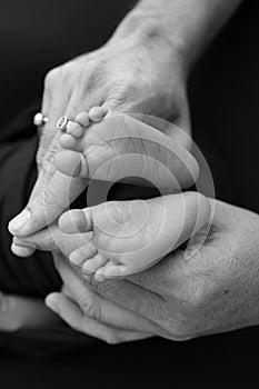 Black white shade beautiful shape hands of mother, hold tiny newborn baby feet