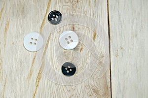 Black and white shirt buttons on wooden table