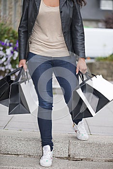 Black and white shopping bags holding by young woman