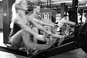 Black And White Shot Of Gym Class Using Rowing Machines