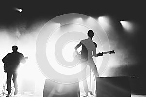 Black and white shot of rock band in a stage backlights