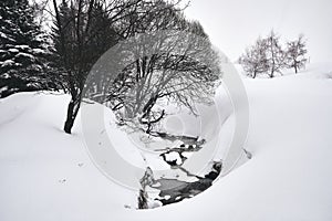 Black and white shot of a stream flowing through the Alpe d Huez ski resort in the French Alps