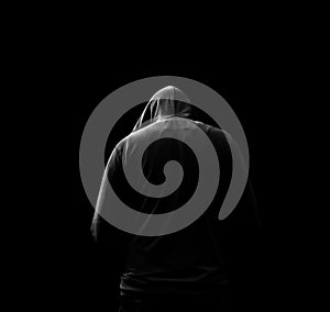 Black and white Silhouette of a hooded man, who turned away, isolated on black background. photo