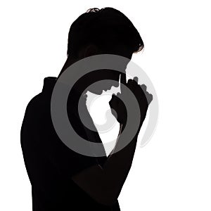 Black and white silhouette portrait of an pensive man with leaning his hand on forehead in stress, guy face profile on a white