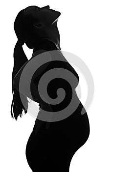 Black and white silhouette portrait of pregnant woman, head tilted up on white background