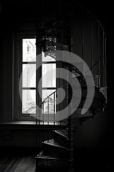 Black and white silhouette of a Victorian era wrought cast iron spiral staircase in a restored building, Singapore