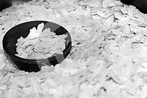 Black and White Small Bowl of Pounding Paddy `POHA` or Flattened rice in pile of Pohe