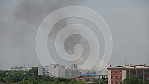 Black and white smokes rising over houses