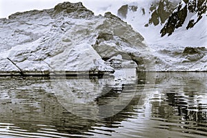 Black and White Snowing Floating Iceberg Arch Reflection Paradise Bay Skintorp Cove Antarctica
