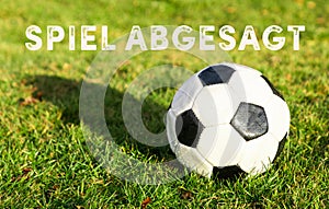 Black white soccer ball with grass german text spiel abgesagt, in english game canceled photo