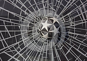 Black and white soccer ball with stars in broken glass