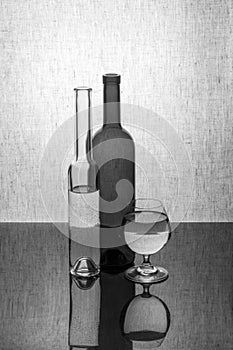 Black and white still life with two bottles and a glass