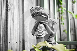 Black and white stone statue of sitting buddha in the garden