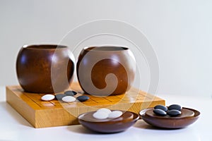 Black and white stones on wooden board with copy space goban, baduk, weiqi board game