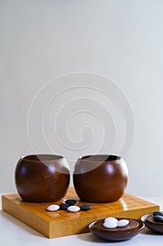 black and white stones on wooden board goban, baduk, weiqi boardgame