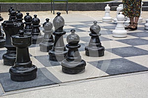 Black and white street chessmen with womans legs