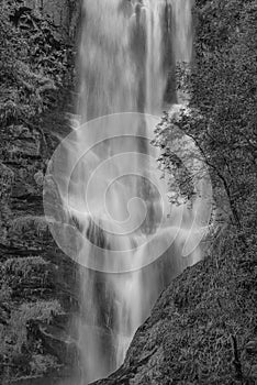 Black and white Stunning long exposure landscape early Autumn image of Pistyll Rhaeader waterfall in Wales, the tallest waterfall