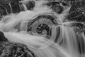 Black and white Stunning vibrant landscape image of Aira Force Upper Falls in Lake District during colorful Autumn showing