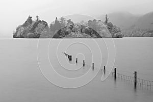 Black and white Stunning vibrant long exposure landscape image of Derwentwater looking towards Catbells peak in Autumn during