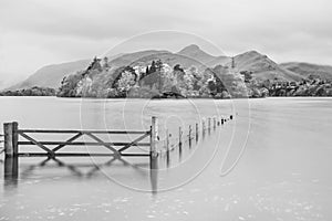 Black and white Stunning vibrant long exposure landscape image of Derwentwater looking towards Catbells peak in Autumn during