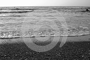 Black and white summer background of hot sand with sea or ocean wave bubbles