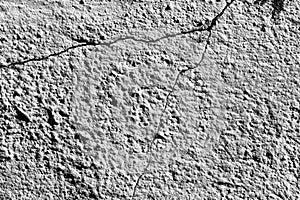 Black and white texture of a concrete wall with a crack