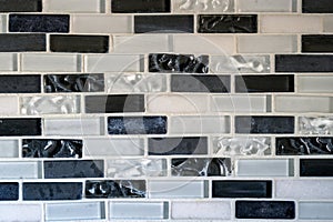 Black and white tiles in a rectangular pattern on an interior kitchen wall
