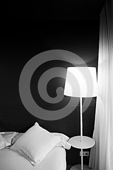 Black and white tone bedroom decoration with lamp and clean linen