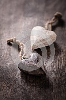 Black and white: two wooden hearts on brown background