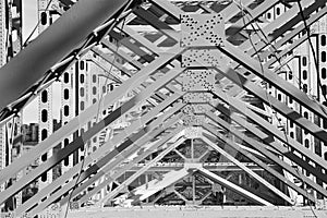 Black and white understory girders of metal bridge