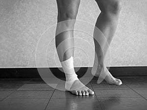 Black and white version of Athlete performing mobility exercises on injured ankle