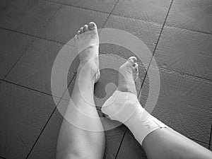 Black and white version of Athlete staring at her injured ankle