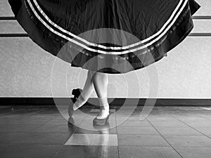 Black and white version of Dancer in Classical position with skirt held in character ballet attire