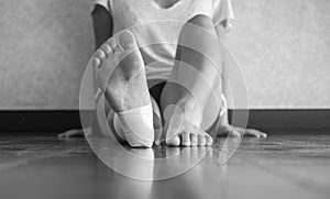 Black and white version of Injured athlete sitting down with an ankle tape job