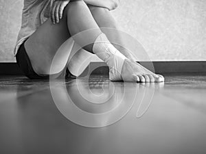 Black and white version of Injured athlete sitting on the sidelines due to ankle sprain