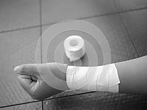 Black and white version of Wrist tape job and roll of tape