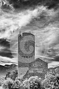 Black and white view of the ancient Frohlich Tower in the historic center of Malles Venosta, South Tyrol, Italy