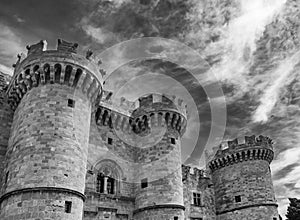 Black and white view of the Palace of the Grand Master of the Knights of Rhodes against a dramatic sky, Greece