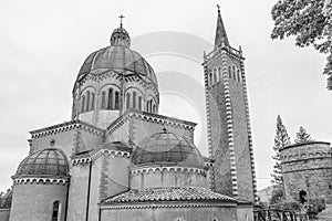 Black and white view of Parish Church of San Mamante and Delubro, Lizzano in Belvedere, Italy, under a dramatic sky photo