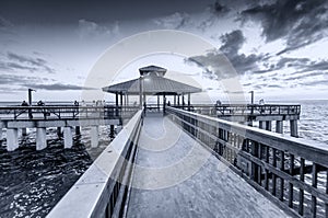 Black and white view of pier at dusk