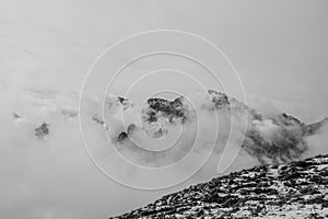 Black and white view of summit of Cima Undici emerging from the clouds