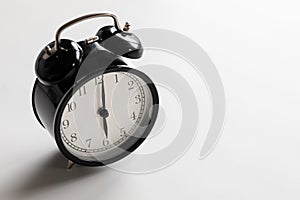 Black and white vintage classic alarm clock at six o`clock with white space