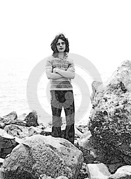 Black and white vintage portrait of a young hippie on the shore.