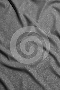 Black and white wavy silk fabric with folds. Mockup and blank designer for making a flag on a gray background