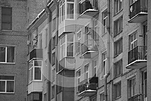 Black and white windows and balconies of a brick house