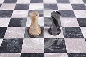 Black and white wooden rooks on chessboard