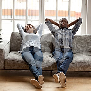 Black wife and husband putting hands behind heads lying resting